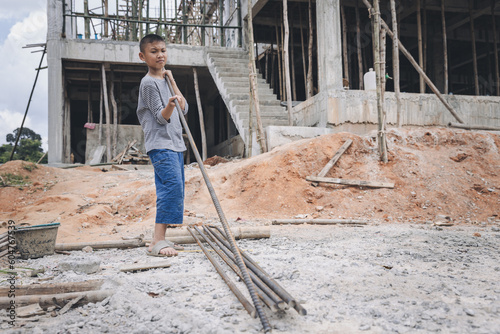 Children violence and abused concept. Little boy labor working in commercial building structure  World Day Against Child Labour concept.