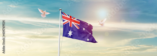 Waving Flag of Australia in Blue Sky. The symbol of the state on wavy cotton fabric.