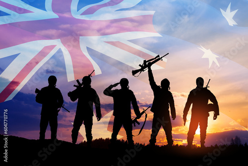 Silhouettes of soldiers on background of Australia flag and the sunset or the sunrise background. Anzac Day.