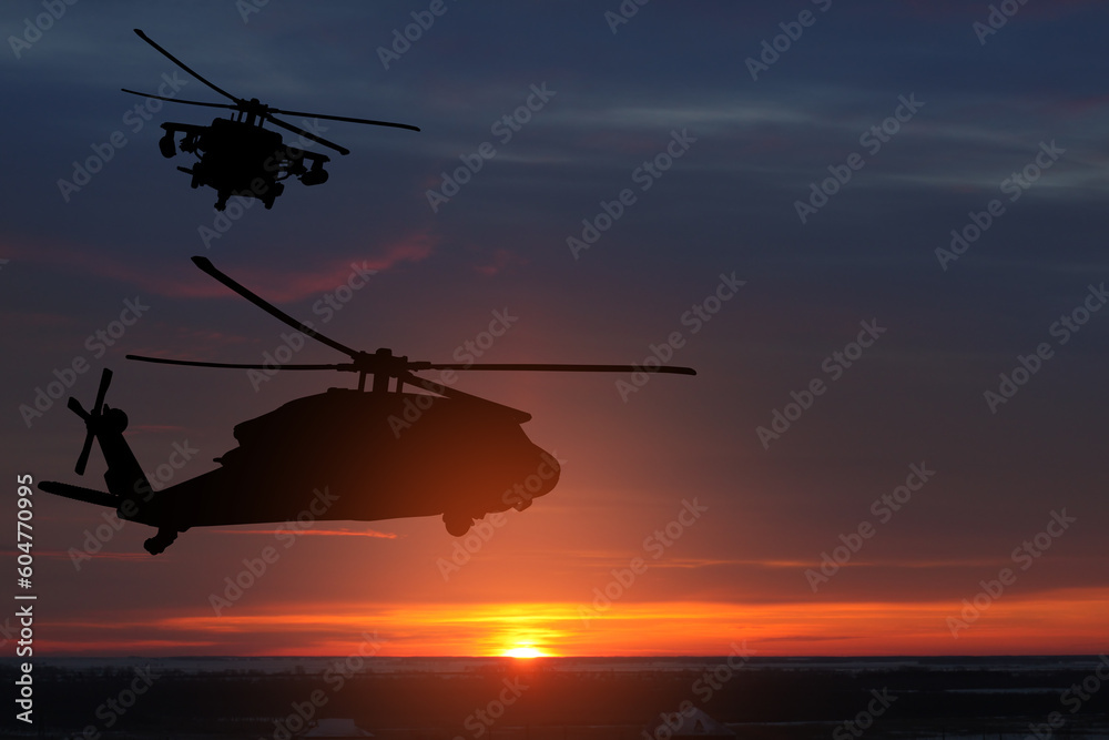 Fototapeta premium Silhouettes of helicopters on background of sunset.