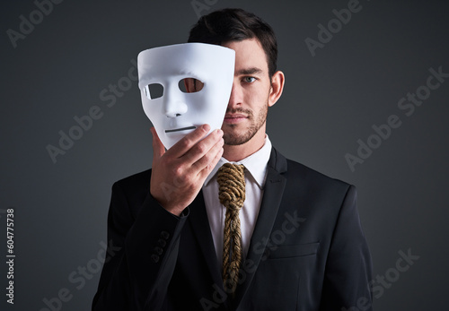 Two faces, holding mask and businessman portrait in a studio with serious face with secret and fraud. Worker or corporate criminal with rope tie showing identity theft or liar in business suit mockup photo