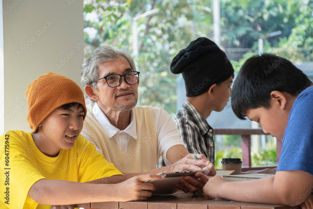 Group of young asian boys are sitting, preparing, choosing, discussing and consulting school subjects with their senior teacher, soft and selective focus on left boy, back to school concept. Group of young asian boys are sitting, preparing, choosing, discussing and consulting school subjects with their senior teacher, soft and selective focus on left boy, back to school concept.