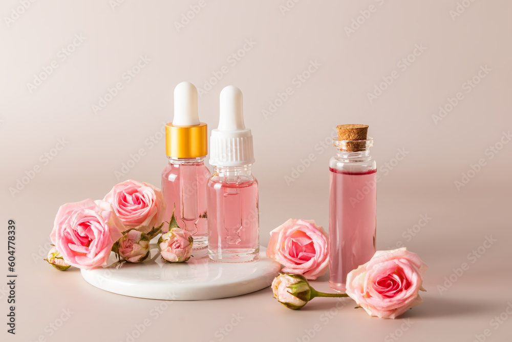 A set of cosmetics in various bottles based on the extract of rose petals on pastel background. facial skin care. natural cosmetics. A set of cosmetics in various bottles based on the extract of rose petals on pastel background. facial skin care. natural cosmetics.