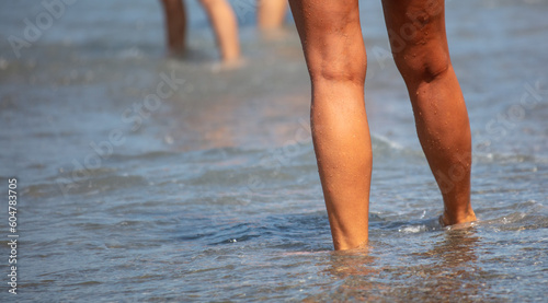 Feet of a woman on a pebbly seashore © schankz