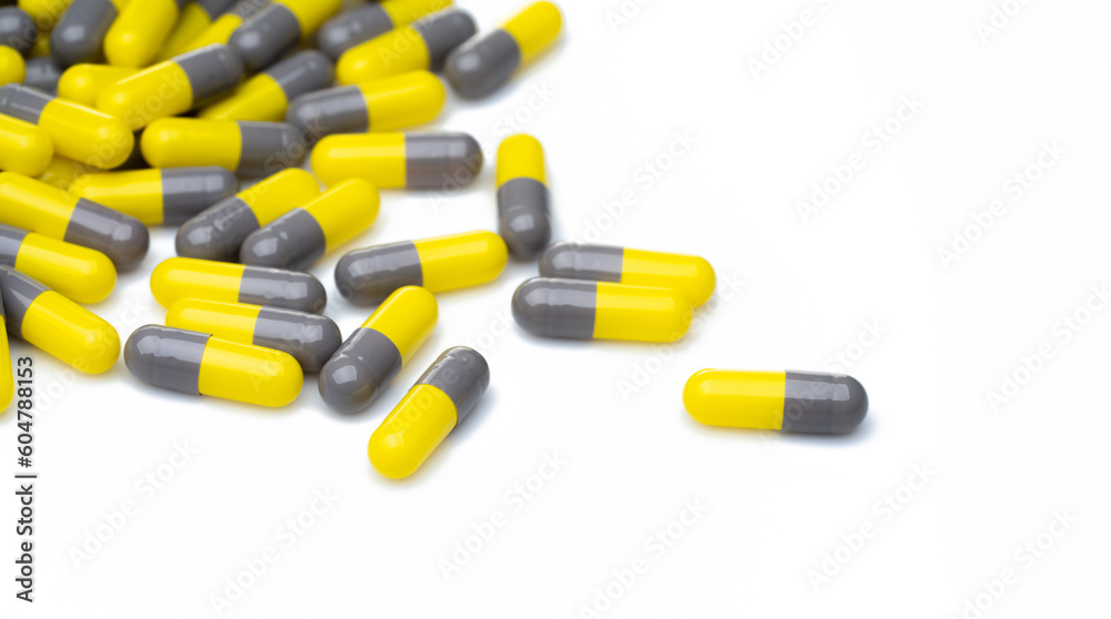 Yellow and gray probiotic capsule pill on white background. Probiotic supplement. Gut health. Dietary supplements. Probiotics for a healthy gut. Lactobacillus acidophilus and Bifidobacterium animalis.