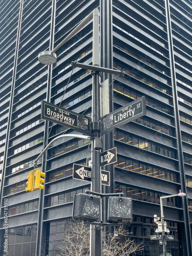 Signs between Broadway and Liberty St. with buildings in the background in Manhattan, New York City.