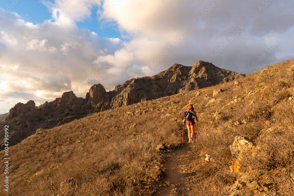 Portrait of a happy woman hiker standing on the top of mountain ridge against mountains - Sport and healthy lifestyle concept