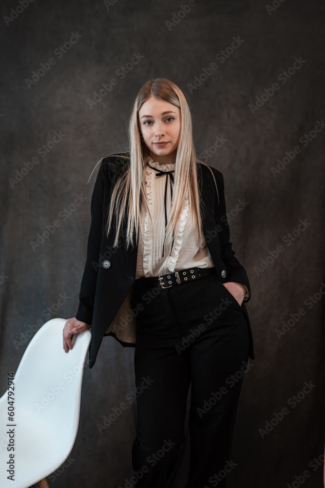 Young caucasian blonde woman wear elegant classic suit isolated on black. Fashion and beauty