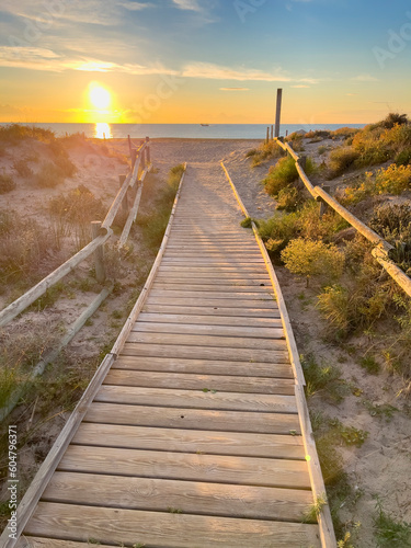 Wooden path access in sand dunes beach at sunset- Spain