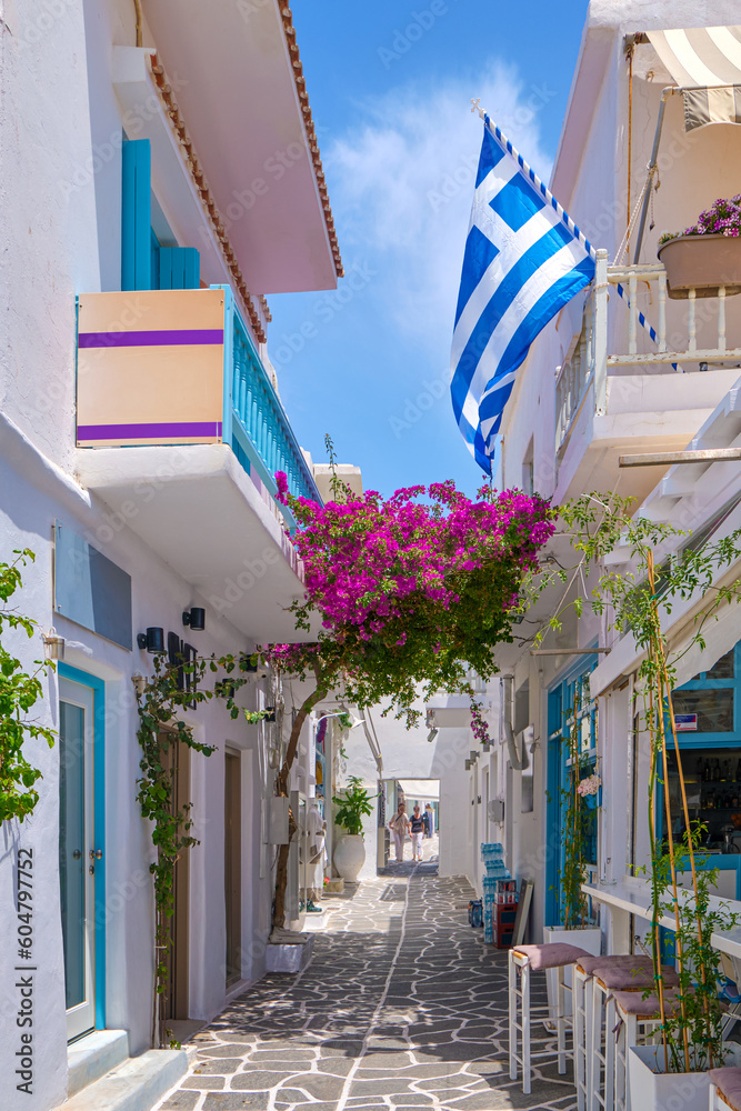 Cozy streets of Greek towns, Greek national flag, bougainvillea