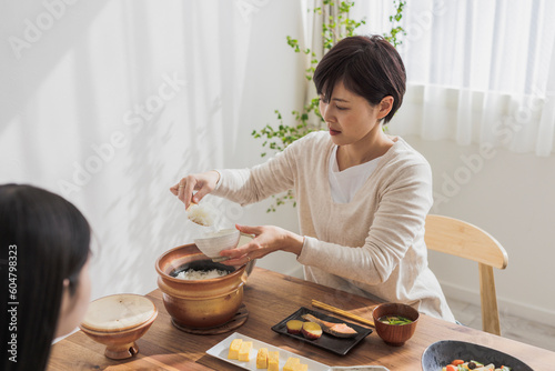 土鍋で炊いたご飯を盛る日本人女性 photo