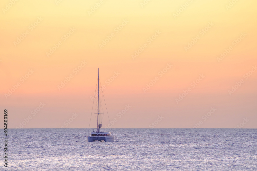 Sailboat on the ocean near the beach at sunset. Sailboat on the ocean near the beach at sunset.