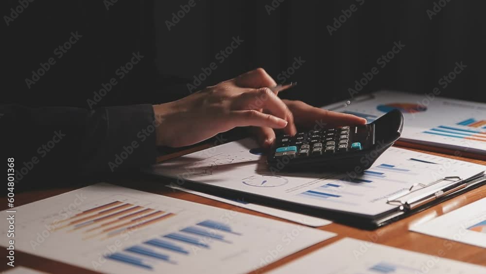 Investors are calculating on calculator investment costs and holding cash notes in hand. Investors are calculating on calculator investment costs and holding cash notes in hand.