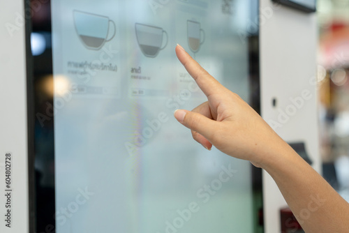 Hand selecting menu on vending machine screen