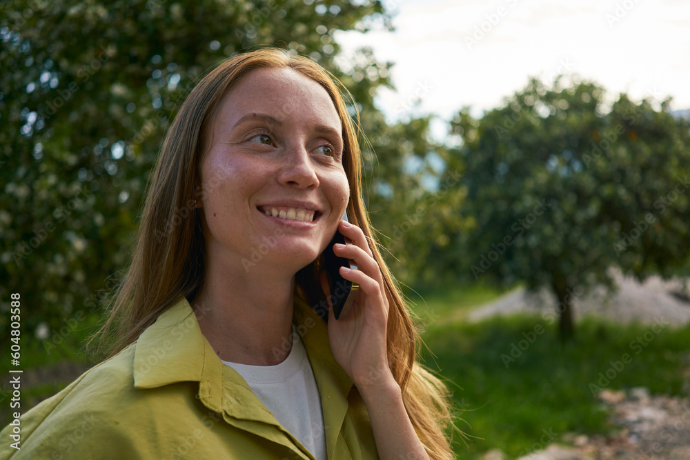 Contemplative woman talking on smart phone at garden Contemplative woman talking on smart phone at garden