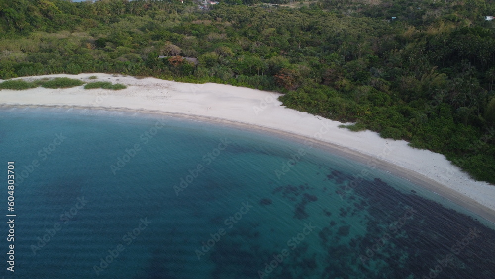 Aerial view of the bay and sea coast. Lagoon and semi-circular sandy beach on a tropical island.