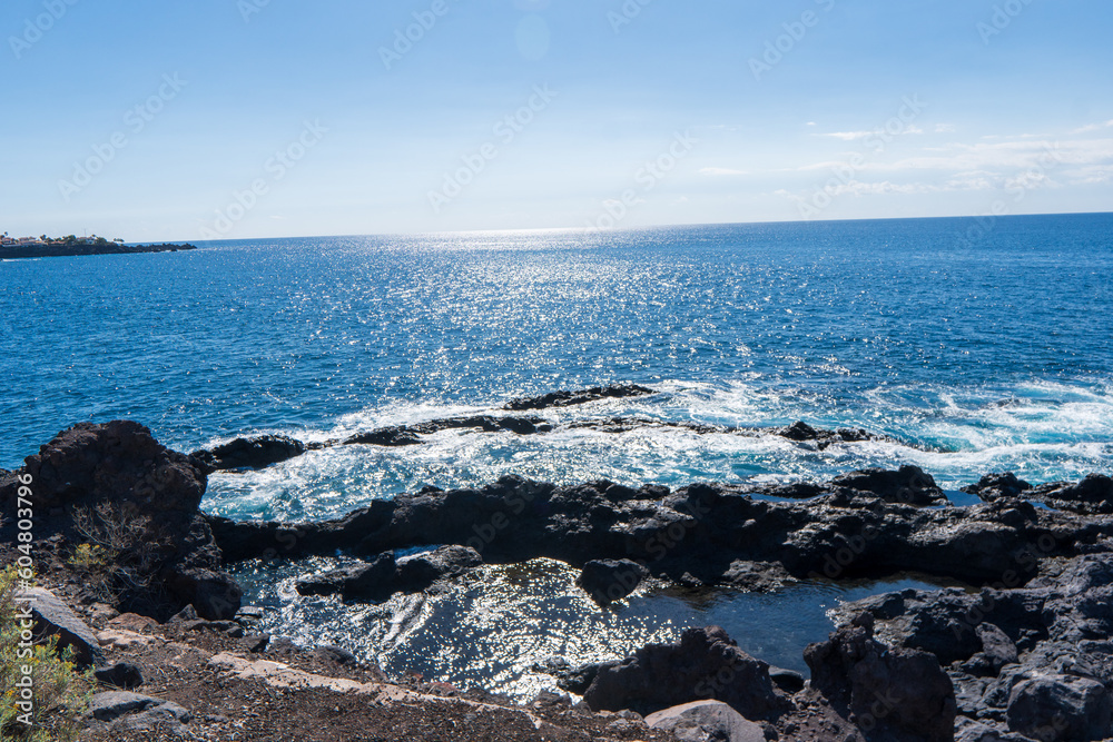 Obraz premium Los Gigantes, Tenerife, Spain - May 14th 2022 - Swimming and enjoying happy hour at sunset in the natural pools of Los Gigantes in Tenerife Canary Islands