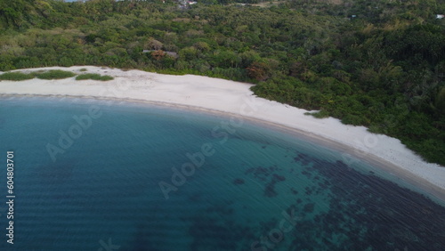 Aerial view of the bay and sea coast. Lagoon and semi-circular sandy beach on a tropical island.
