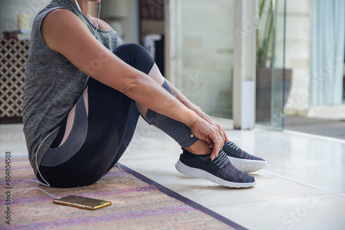 Woman wearing shoes sitting on floor at home