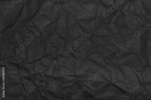 Black wrinkled paper texture. Grunge dark background