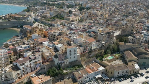 This aerial drone video shows the beautiful coastal city of Castellammare Del Golfo in Sicily, southern Italy. The city has old architecture and a marina wherefrom boats sail on the mediterranean sea. photo