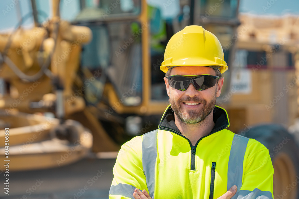 Construction worker at house under construction. Builder in building uniform on construction background. Builder at the construction site. American worker with helmet. Bilder in hardhat. Construction worker at house under construction. Builder in building uniform on construction background. Builder at the construction site. American worker with helmet. Bilder in hardhat.