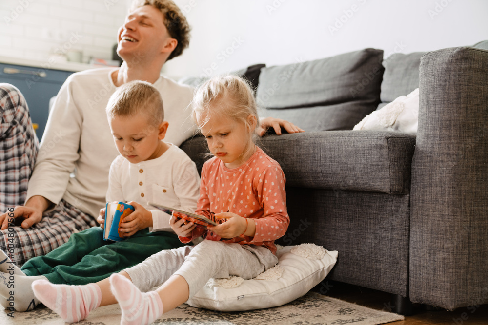 Fototapeta premium Father and his children spending time together at home