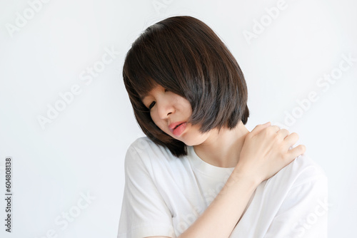 Woman showing pain in shoulder because of muscle inflammation.