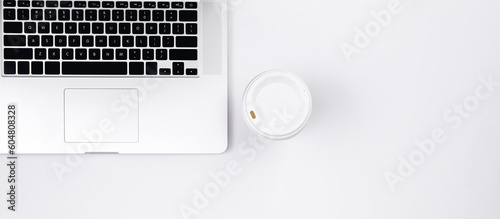 Laptop and a cup of coffee on a white background, top view.