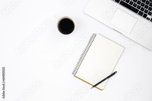 White background with laptop, notepad and coffee, top view.
