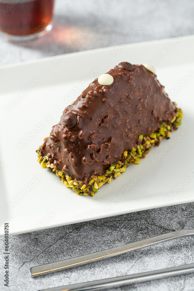 Dessert Cake from Malaga on stone table. Cake with banana inside, covered with chocolate sauce and hazelnuts Dessert Cake from Malaga on stone table. Cake with banana inside, covered with chocolate sauce and hazelnuts
