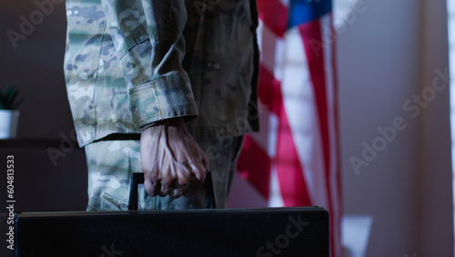 Soldier carries a work suitcase and confidential documents in American office