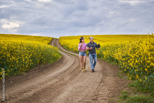 Farmers couple examining canola fields