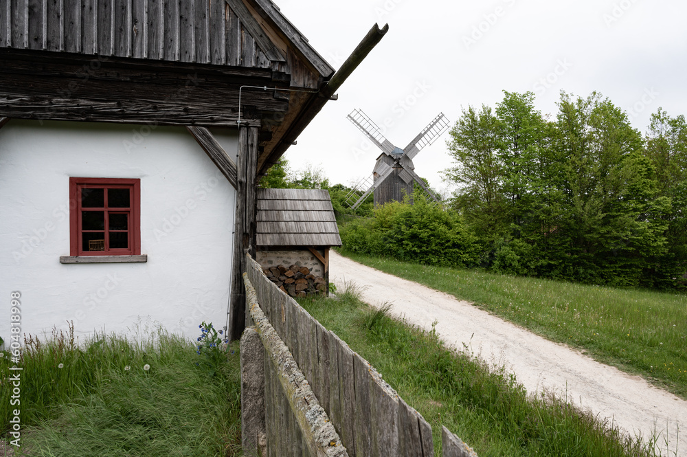 Altertümliches Bauernhaus mit Windmühle im Hintergrund