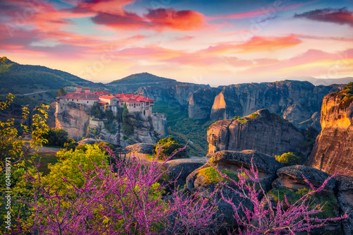 Blossoming cherry trees in outskirts of famous Eastern Orthodox monasteries listed as a World Heritage site, built on top of rock pillars. Superb spring sunrise in Greece, Europe.