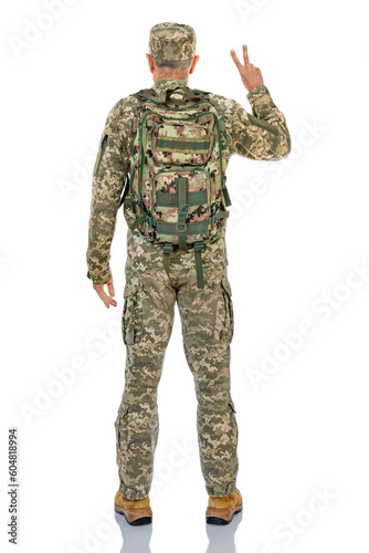Back side full-length portrait of soldier making v-signs isolated on white background. Fifty years old defender stands straight and posing in studio.