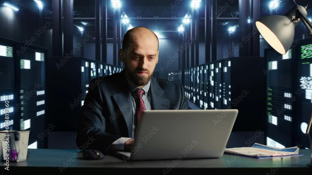 Technician using pc in 3d server room, doing research for database hardware at desk. Businessman engineer sitting in render farm to work on data processing industry. 3d render animation. Technician using pc in 3d server room, doing research for database hardware at desk. Businessman engineer sitting in render farm to work on data processing industry. 3d render animation.