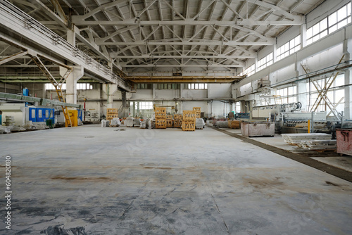 Horizontal image of big empty warehouse with equipment and materials