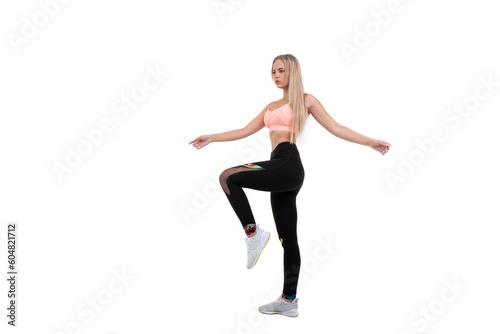 Sporty beautiful blonde in a pink top, leggings and sneakers posing on a white background