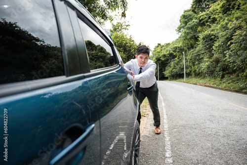 Asian businessman car broken has problems with car down during go to work in morning he pushing out of gas on road at countryside, business man have trouble roadside, problem transportation © sorapop
