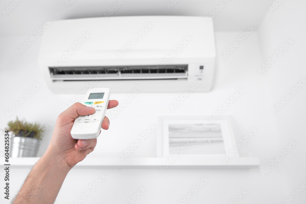 Man holding a modern AC unit remote.