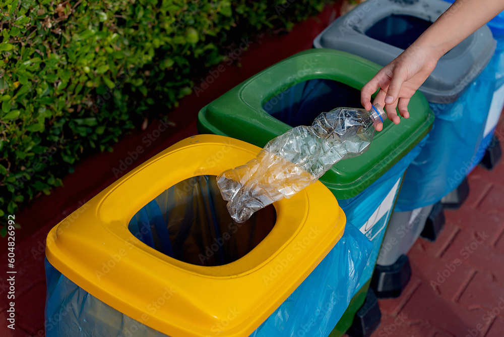 Close up hand throwing plastic bottle recycling container garbage