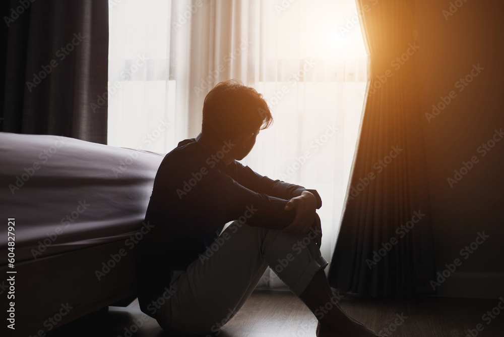 The young man was sitting in the bedroom. He was looking out the window and felt sorrowful feeling unhappy in personal life He has problems and fights with his girlfriend and tends to break up. - obrazy, fototapety, plakaty 
