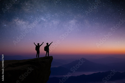 Silhouette of couple young traveler and backpacker watched the star and milky way alone on top of the mountain. He enjoyed traveling and was successful when he reached the summit.