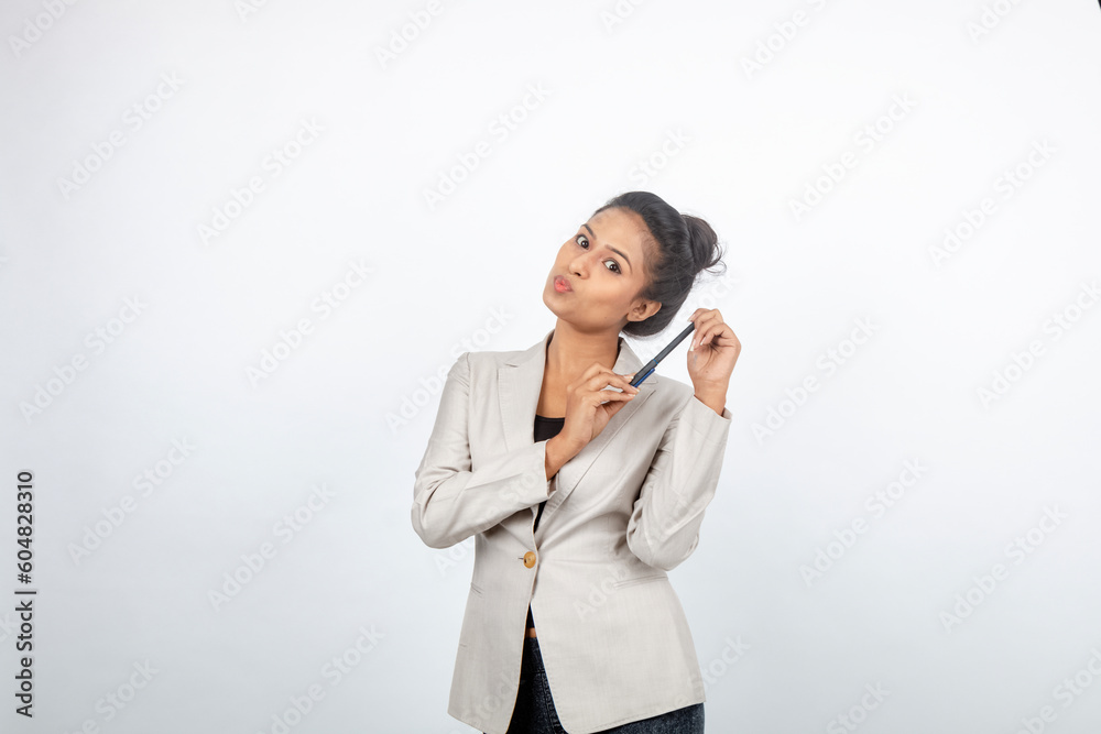 Corporate office lady with black hair having playful moment with pen, smart phone in formal wear wearing white blazer against white background. Corporate office lady with black hair having playful moment with pen, smart phone in formal wear wearing white blazer against white background.