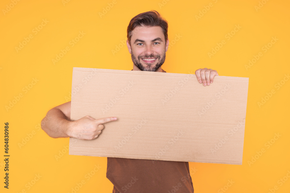 Man holds sign, blank card. Placard ready for your product. Sign to your text. Man showing blank sign board over studio isolated background, pointing finger. Empty blank board. Area for advertising. Man holds sign, blank card. Placard ready for your product. Sign to your text. Man showing blank sign board over studio isolated background, pointing finger. Empty blank board. Area for advertising.