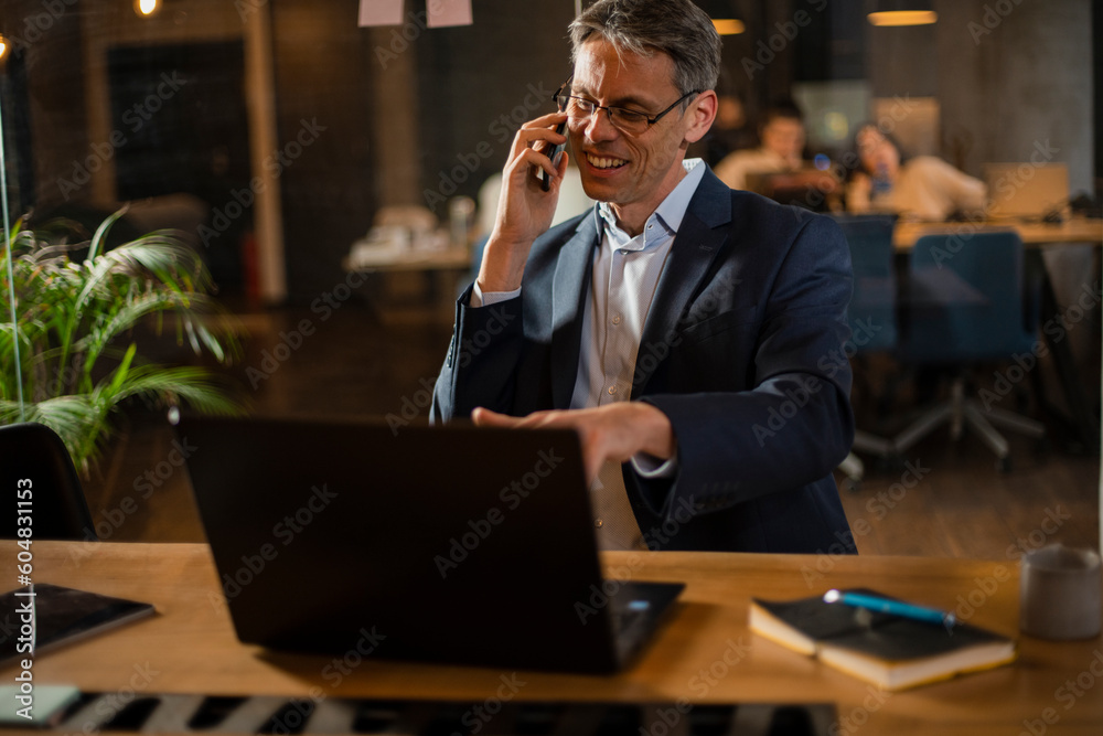 Businessman in office. Handsome man talking on phone at work. Businessman in office. Handsome man talking on phone at work.