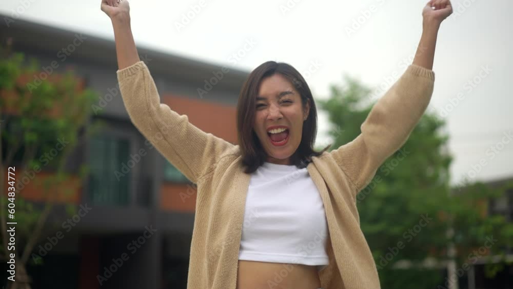 Happy feeling of woman buying or rent new home she holding key front of new house. Surprised happy young asian woman and smile to renter or purchase apartment, home. Moving day relocation concept.