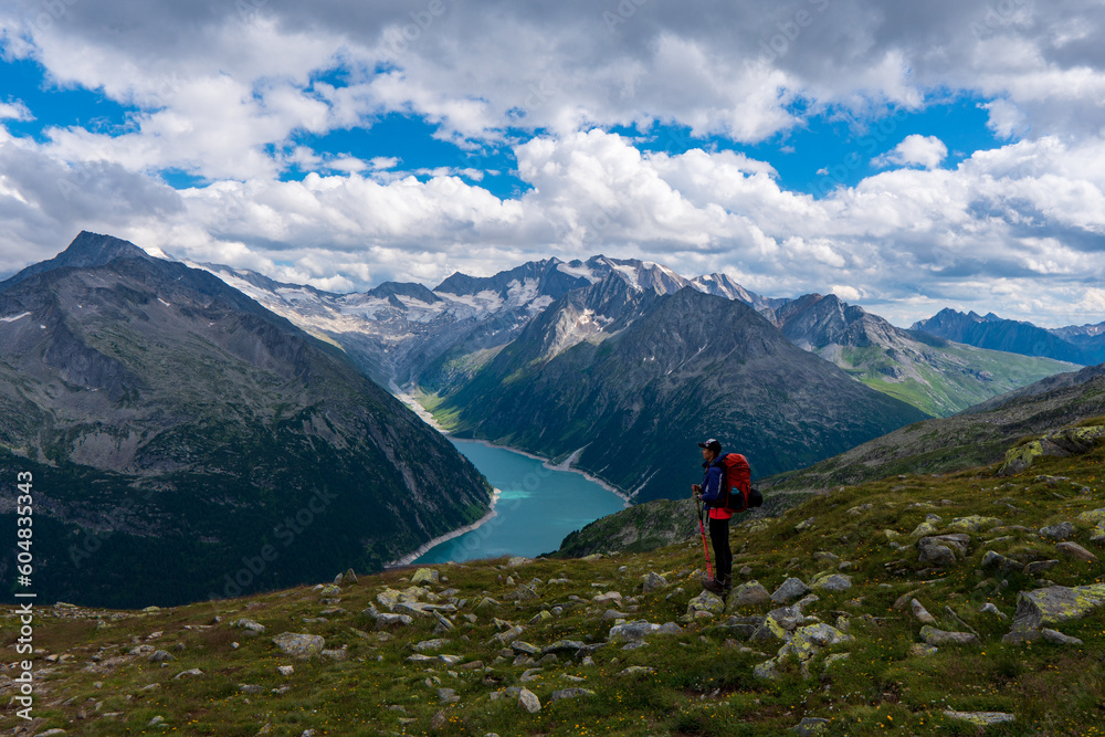 Young woman on a mountain trail, in the background the beautiful alpine landscape, Zillertal Alps, Austria