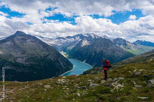 Young woman on a mountain trail, in the background the beautiful alpine landscape, Zillertal Alps, Austria